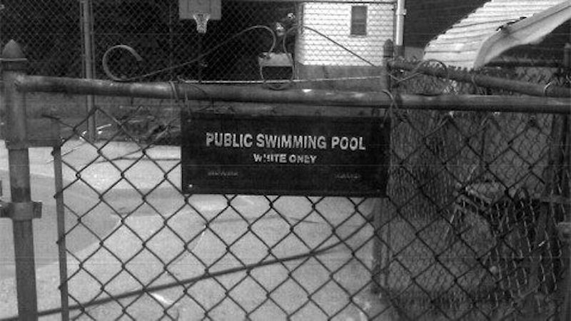Sign on pool gate with text 'whites only'. Credit mondoweiss