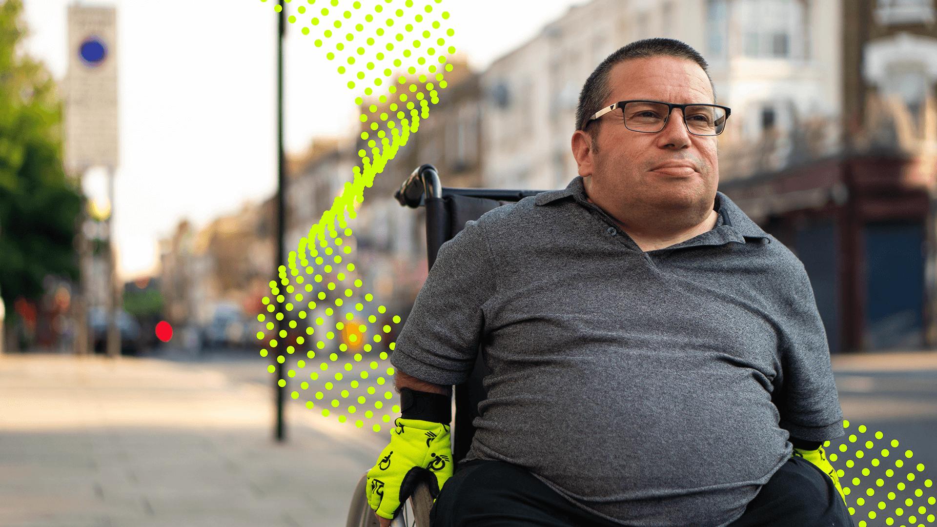 Image for A wheelchair user travelling through a street with the McPin ribbon wrapping them.