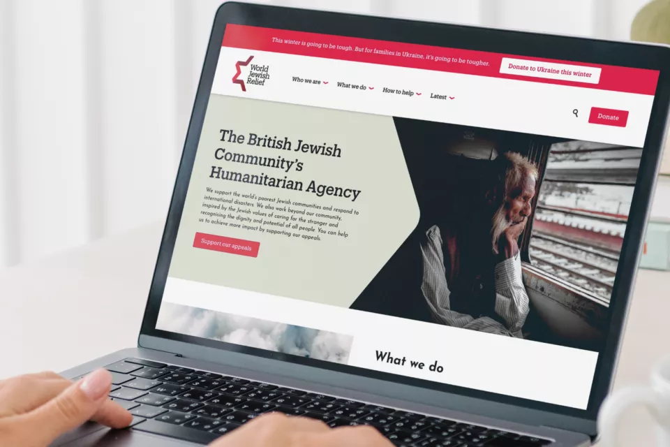 A person viewing the new World Jewish Relief charity website design on their laptop, created by charity design agency Studio Republic